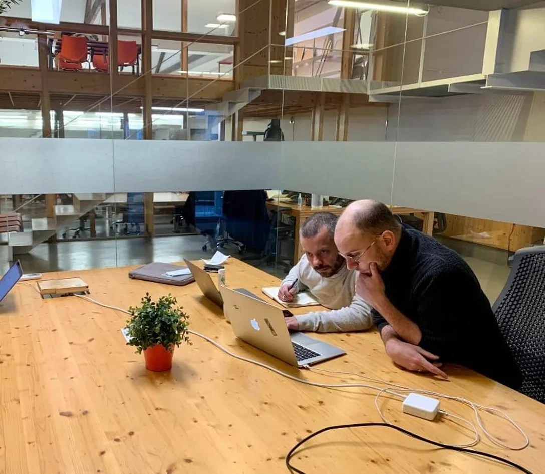 Deux consultants EdgeAngel au travail devant un écran, dans les bureaux de l'agence